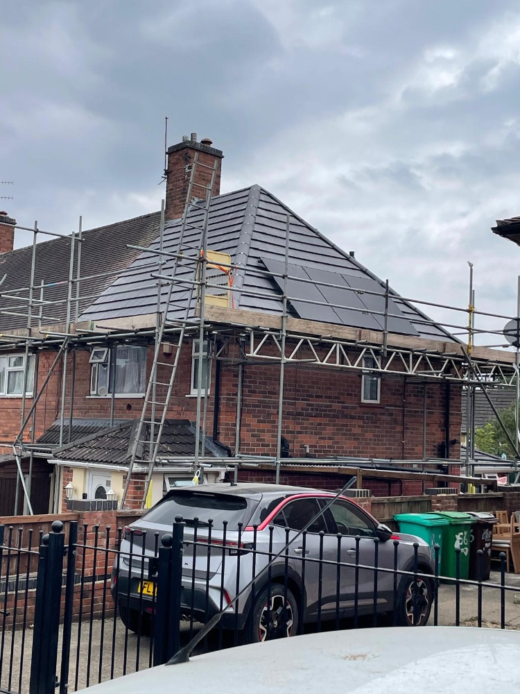 Reroof with on-roof solar. Roof renewal and a panel array, with scaffolding still in place.