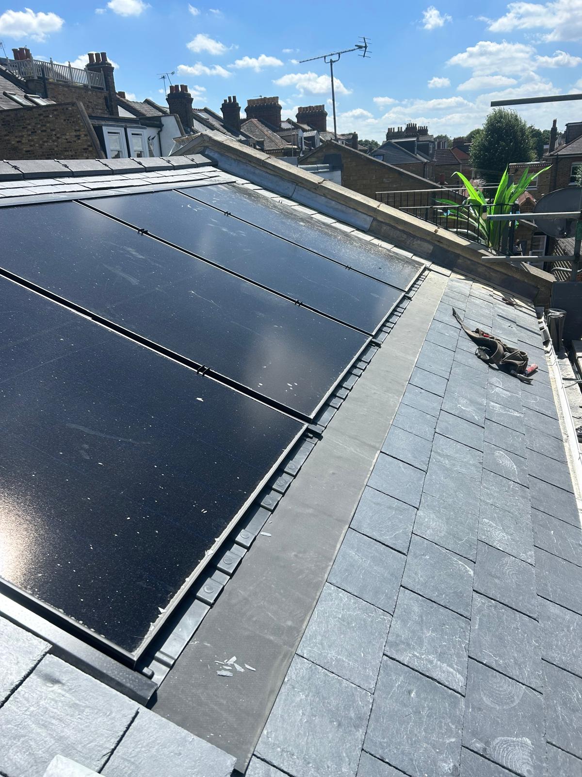 A new slate roof with in-roof panels. The transition between solar panels and the surrounding slate roof covering.
