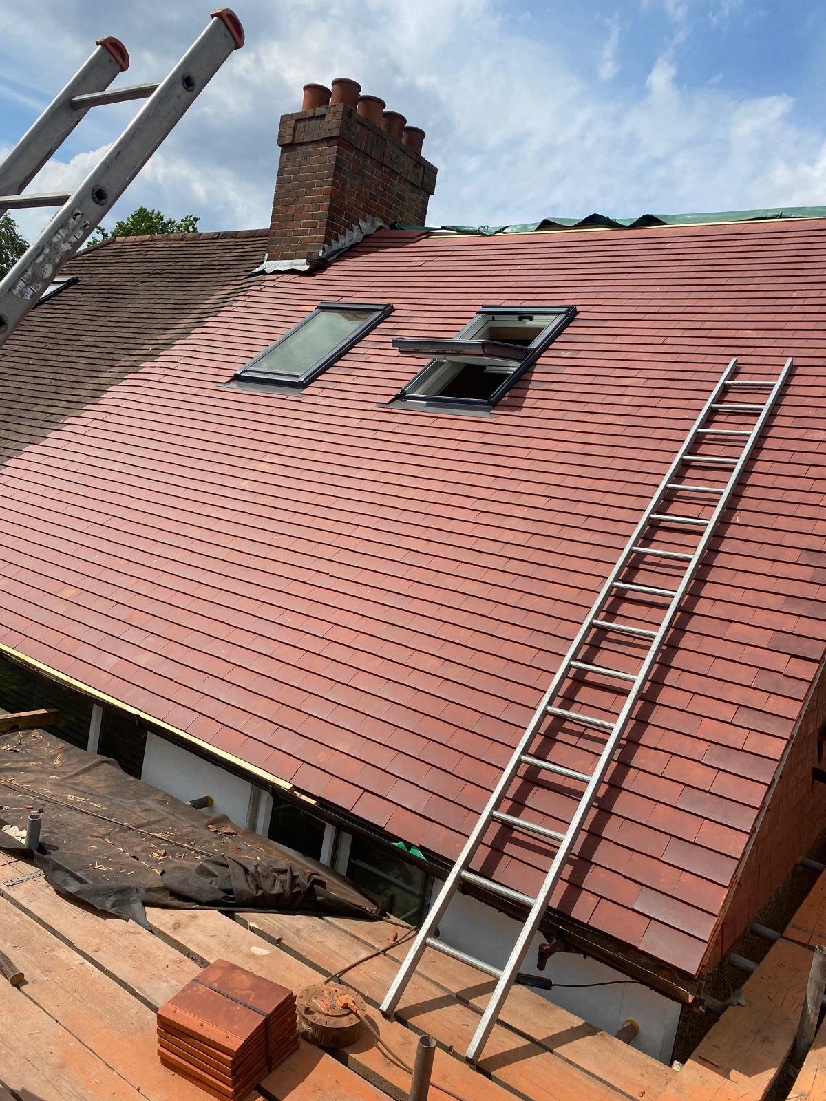 Terracotta roofing with rooflights. New roof covering and rooflights, photographed while work was in progress.